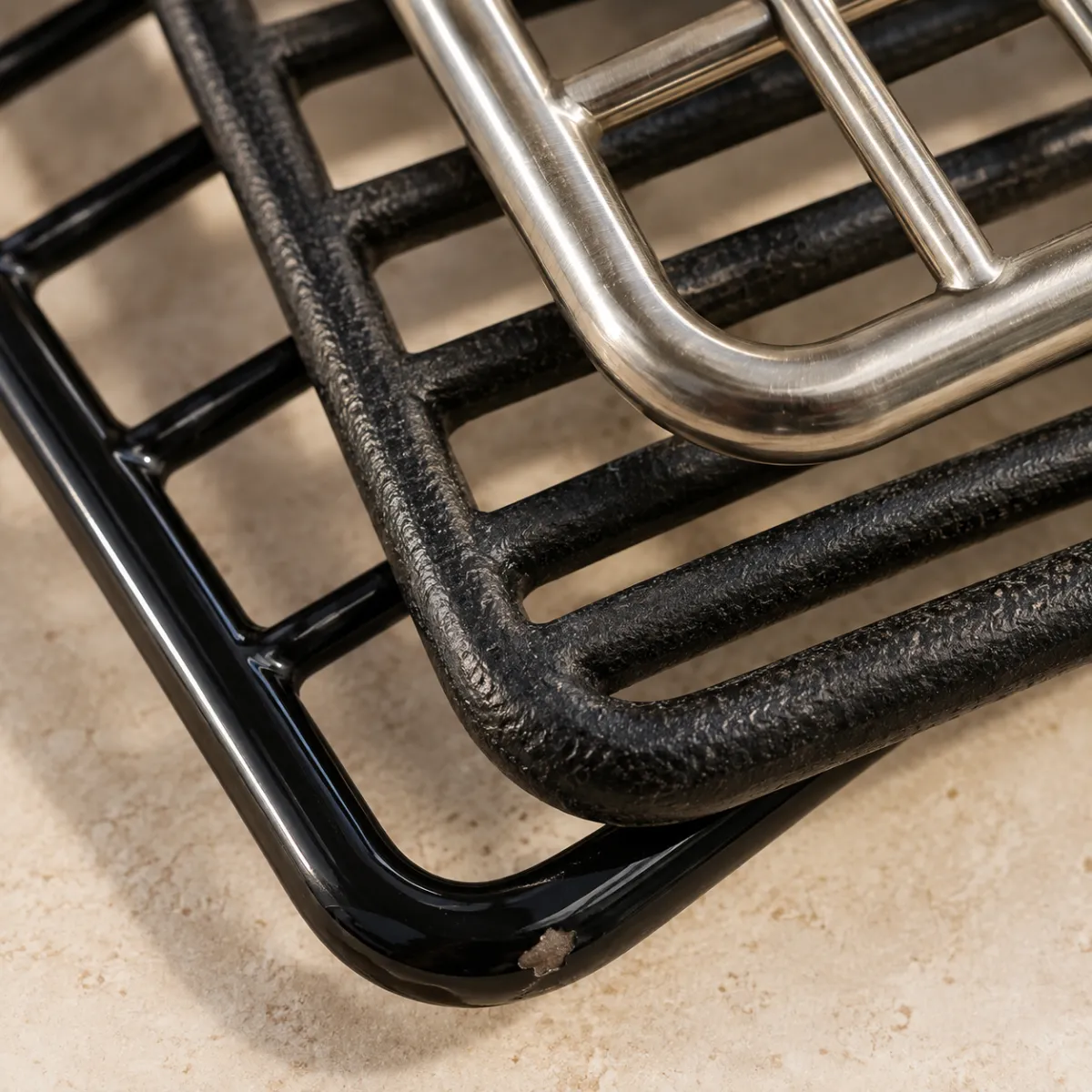 Close-up of stainless steel, cast iron and porcelain-coated grill rack bars compared